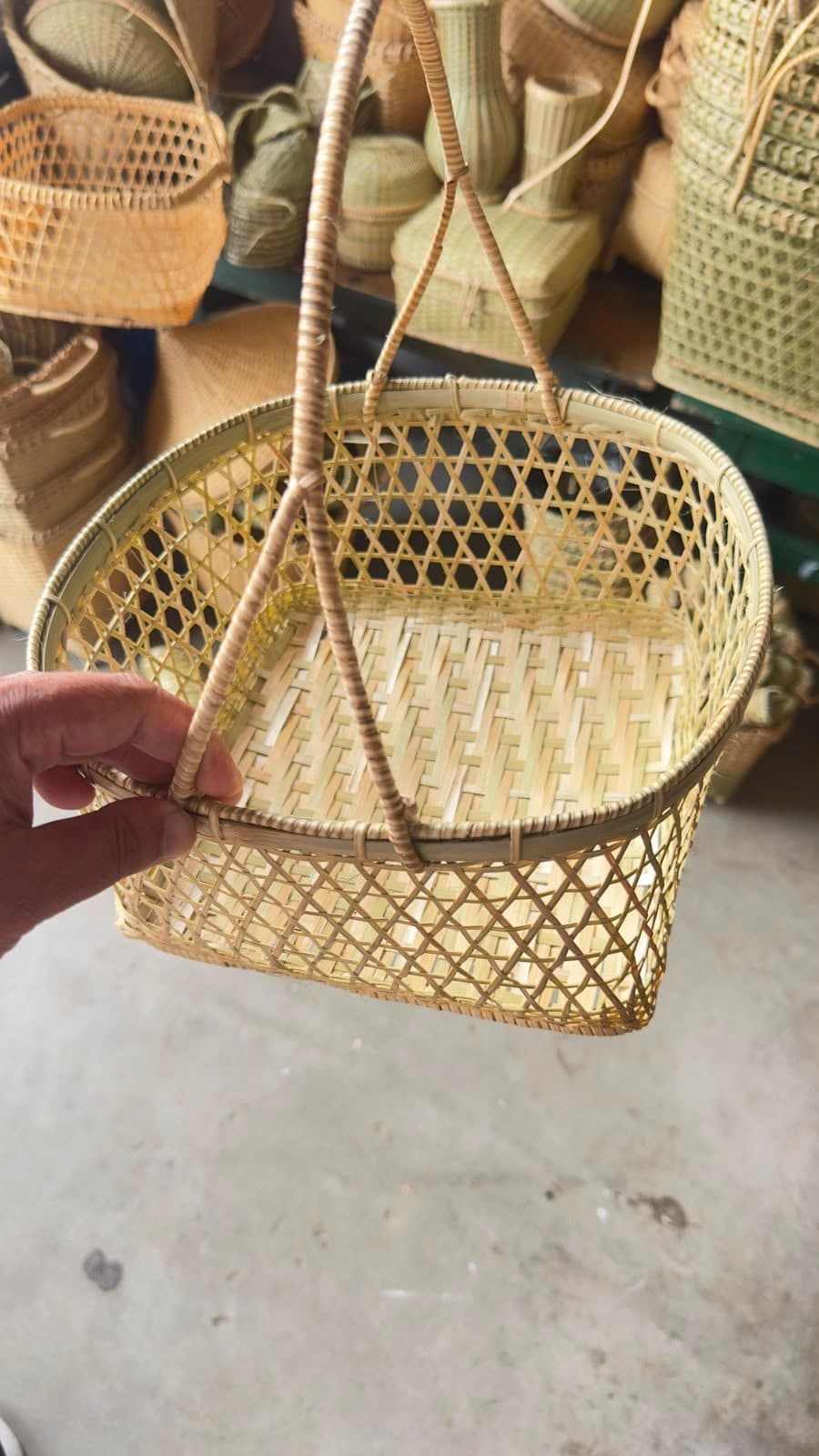 Oval bamboo market basket with hexagonal lattice sides and arch handle