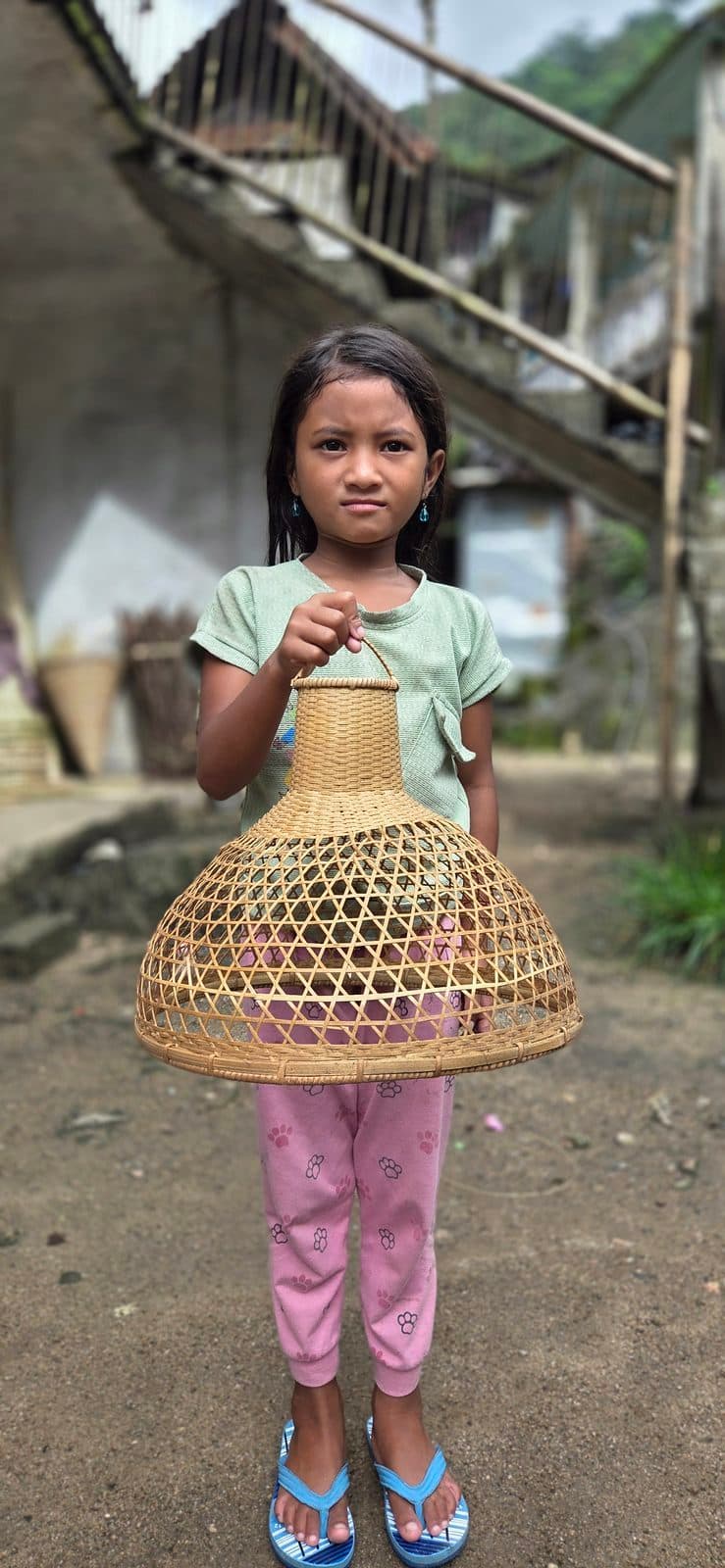 Bamboo sun hat being worn in a village setting